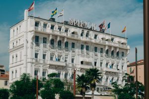 Elegant facade of Hotel Splendid in Cannes with vibrant flags under a sunny sky. — Holiday to A holiday in greece - The Area